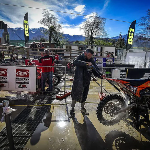 Enduro bike being pressure-washed at a paddock wash bay